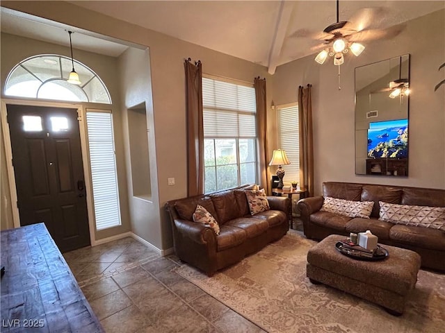 living room featuring stone tile floors, a ceiling fan, baseboards, and lofted ceiling with beams