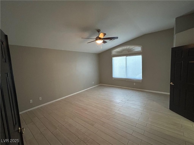 empty room featuring light wood-style floors, baseboards, a ceiling fan, and vaulted ceiling