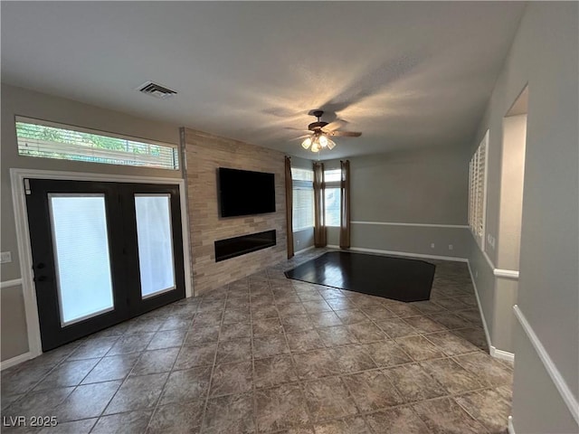 unfurnished living room featuring a ceiling fan, baseboards, visible vents, and a large fireplace