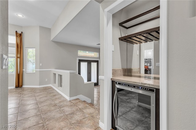 3047 Whispering Crest Dr, Henderson, NV 89052 - kitchen featuring wine cooler, plenty of natural light, stainless steel double oven, and light tile patterned flooring