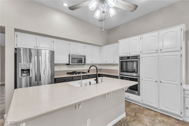 3047 Whispering Crest Dr, Henderson, NV 89052 - kitchen with stainless steel appliances, a sink, white cabinets, ceiling fan, and light countertops