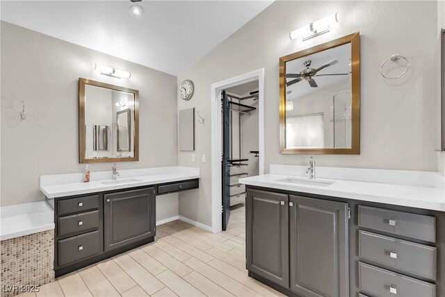 3047 Whispering Crest Dr, Henderson, NV 89052 - full bathroom featuring two vanities, lofted ceiling, a relaxing tiled tub, and a ceiling fan
