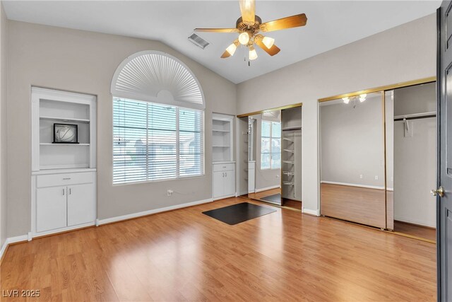 3047 Whispering Crest Dr, Henderson, NV 89052 - unfurnished bedroom with two closets, lofted ceiling, light wood finished floors, and baseboards