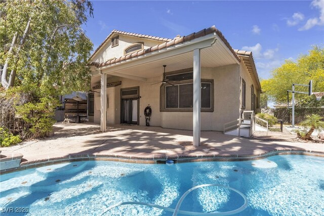3047 Whispering Crest Dr, Henderson, NV 89052 - back of property with stucco siding, a ceiling fan, an outdoor pool, a patio, and a tile roof