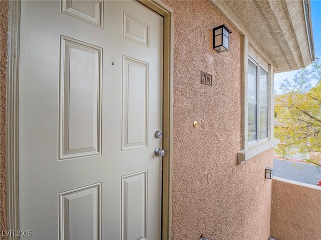 property entrance featuring stucco siding