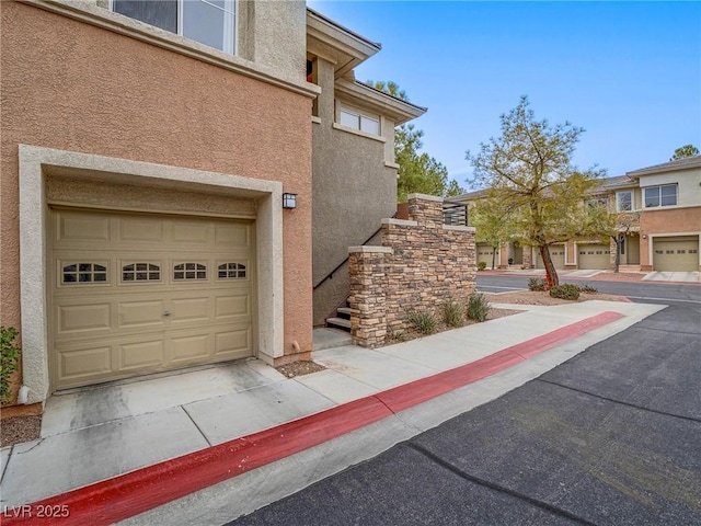 view of side of property with a garage and stucco siding