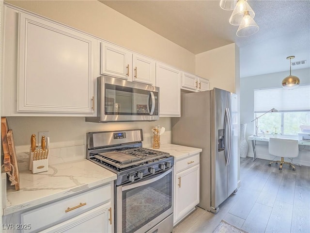 kitchen featuring light stone counters, stainless steel appliances, visible vents, white cabinetry, and light wood-type flooring