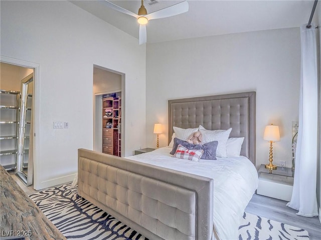 bedroom featuring a ceiling fan, baseboards, and wood finished floors