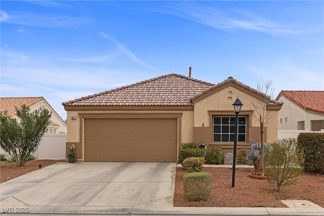 view of front of home with stucco siding, concrete driveway, an attached garage, fence, and a tiled roof