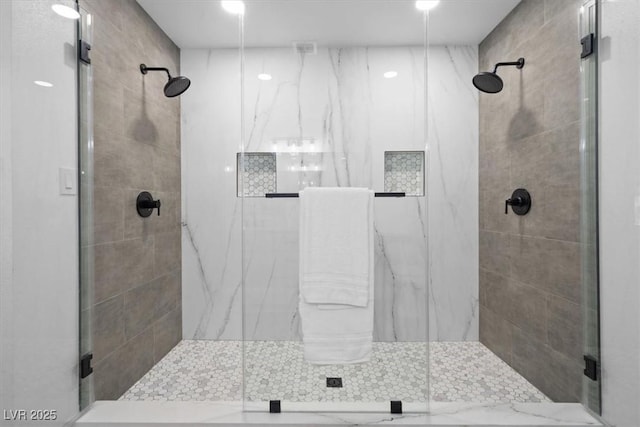 bathroom featuring a marble finish shower