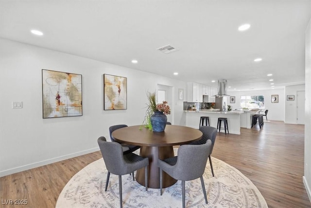 dining room with recessed lighting, visible vents, light wood-style flooring, and baseboards