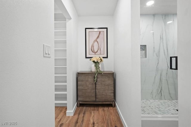 corridor with wood finished floors and baseboards