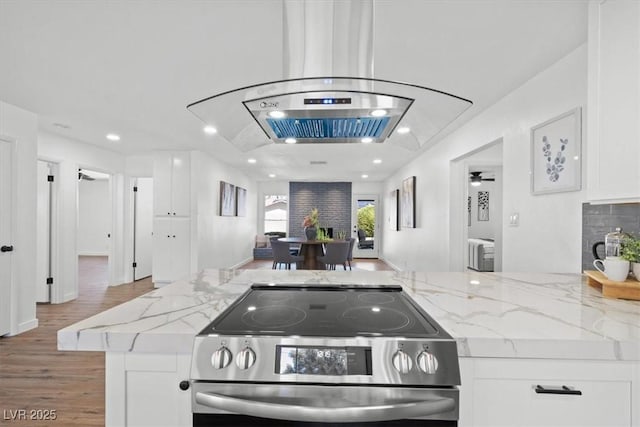 kitchen featuring wood finished floors, white cabinets, stainless steel electric range, and light stone countertops