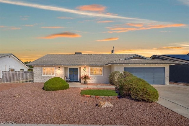 ranch-style home with fence, a garage, driveway, and stucco siding