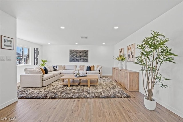 living room featuring recessed lighting, visible vents, baseboards, and wood finished floors