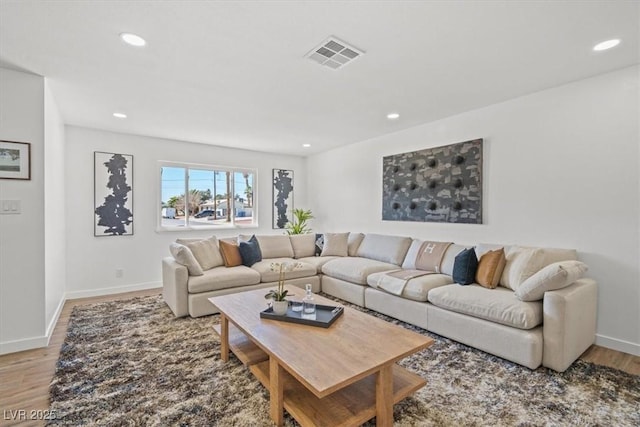 living area with baseboards, wood finished floors, visible vents, and recessed lighting