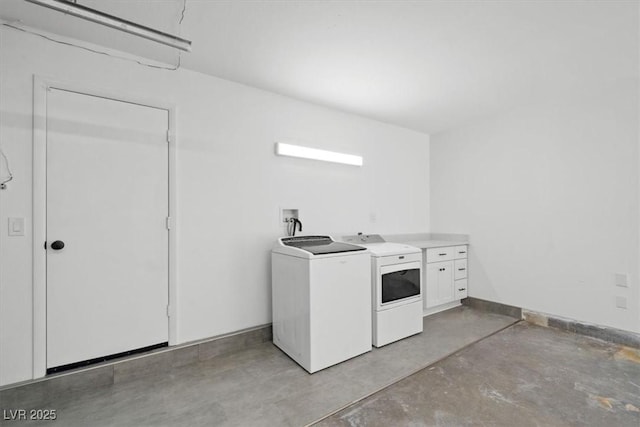 laundry room with cabinet space, baseboards, and washer and dryer