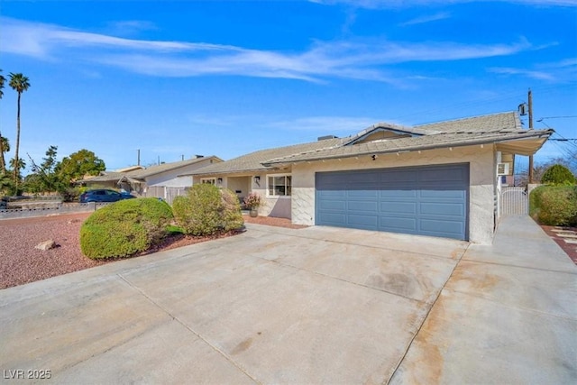 ranch-style house featuring a garage, driveway, a gate, and stucco siding