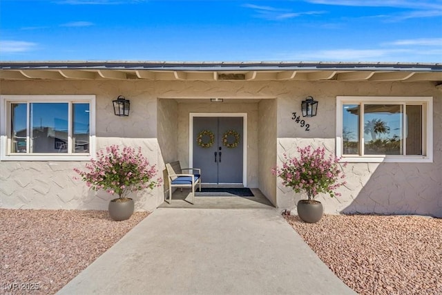 entrance to property featuring stucco siding