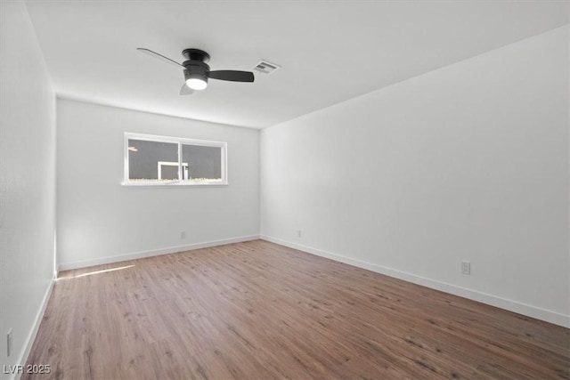 unfurnished room with a ceiling fan, baseboards, visible vents, and wood finished floors