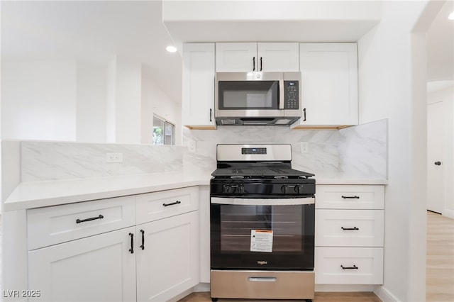 kitchen with white cabinetry, appliances with stainless steel finishes, decorative backsplash, and light countertops