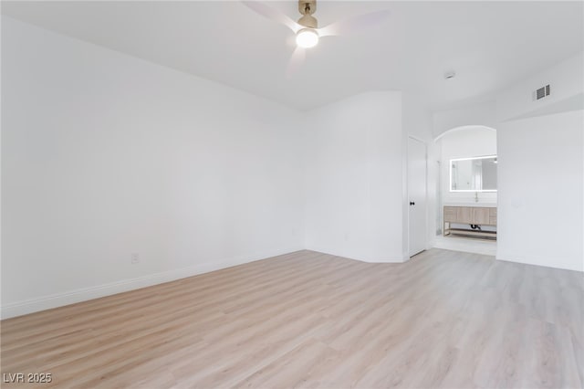 spare room featuring visible vents, baseboards, light wood-style flooring, and a ceiling fan