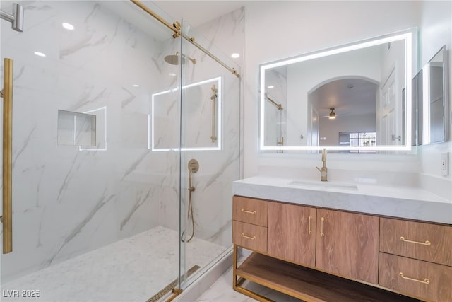 bathroom with marble finish floor, ceiling fan, a marble finish shower, and vanity