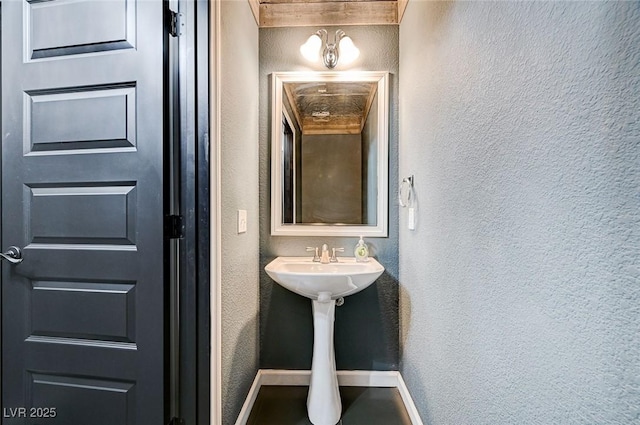 bathroom with baseboards and a textured wall