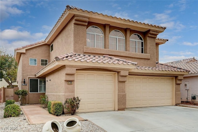 mediterranean / spanish home featuring stucco siding, driveway, a tile roof, and a garage