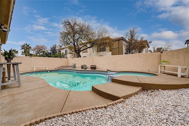 view of pool featuring a patio, a fenced backyard, and a pool with connected hot tub