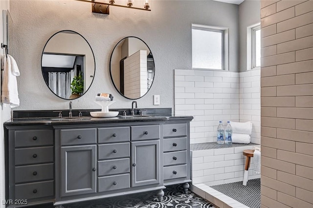 full bathroom with a sink, a shower with shower curtain, double vanity, and tile patterned flooring