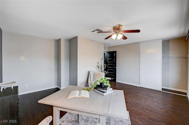 office area with ceiling fan, visible vents, baseboards, and wood finished floors