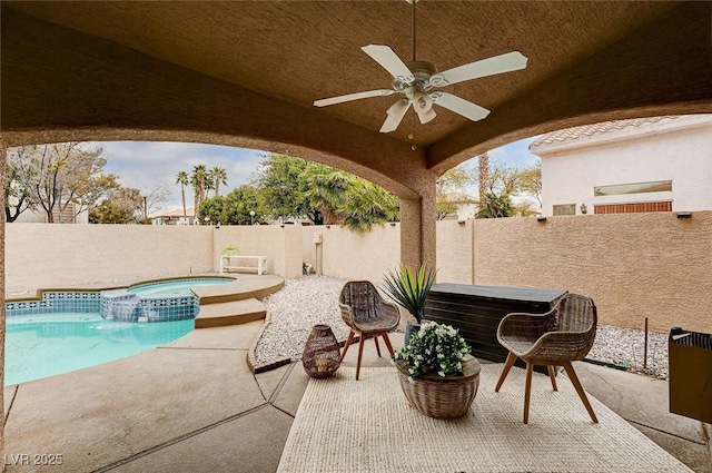 view of patio featuring ceiling fan, a fenced backyard, and a pool with connected hot tub