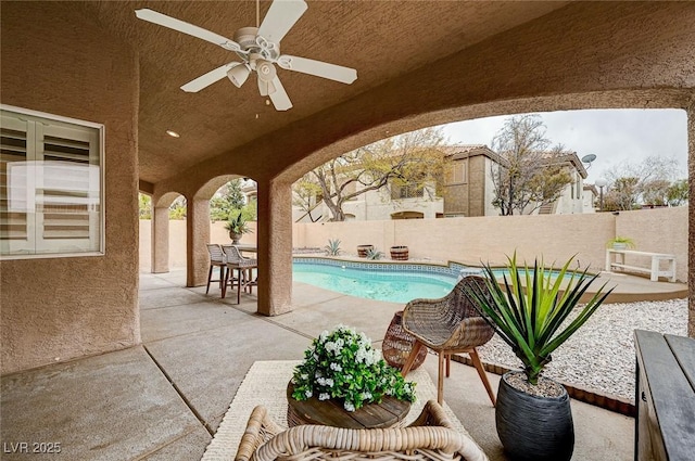 view of swimming pool with a fenced backyard, a fenced in pool, a ceiling fan, and a patio