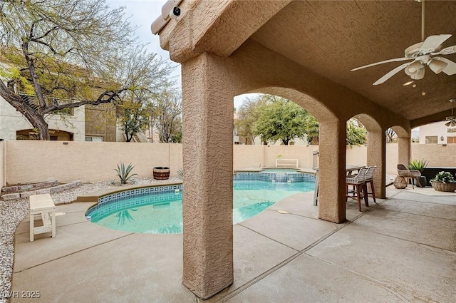 view of swimming pool featuring a ceiling fan, a patio, a fenced backyard, and a pool with connected hot tub