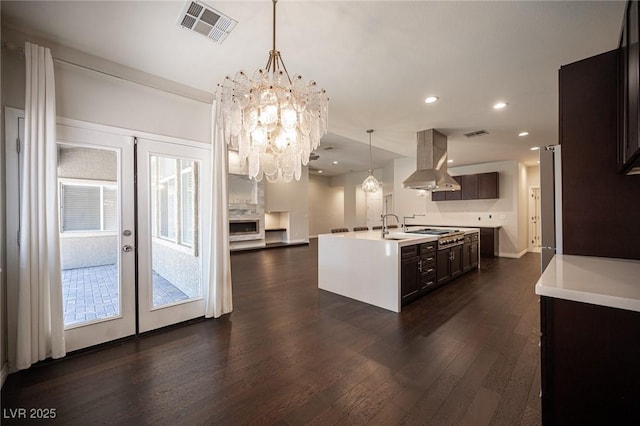 kitchen with french doors, dark wood finished floors, light countertops, visible vents, and island range hood