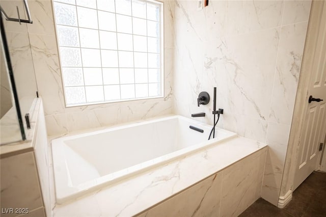 bathroom featuring tile walls and a bath