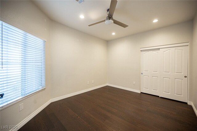 unfurnished bedroom featuring dark wood-type flooring, a closet, recessed lighting, and baseboards