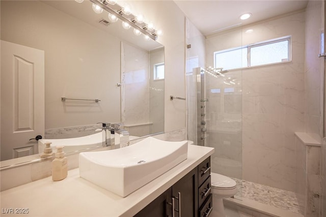 bathroom with toilet, recessed lighting, visible vents, vanity, and a tile shower