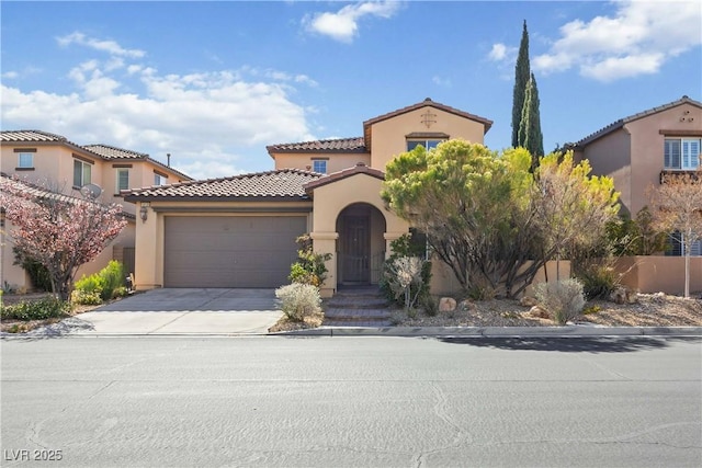 mediterranean / spanish home with a tiled roof, an attached garage, driveway, and stucco siding