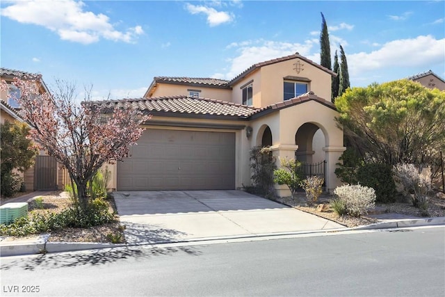 mediterranean / spanish house featuring stucco siding, an attached garage, driveway, and fence