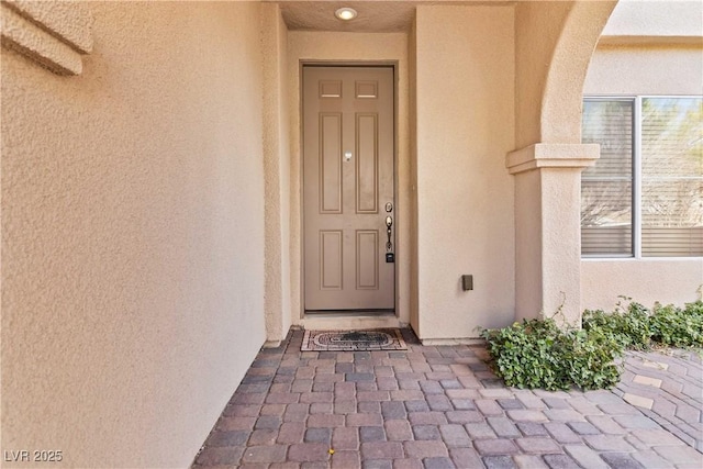 property entrance with stucco siding