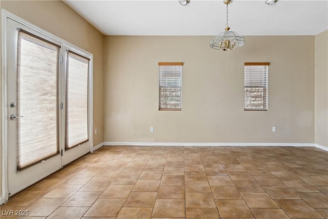 unfurnished room with light tile patterned flooring, baseboards, and a chandelier