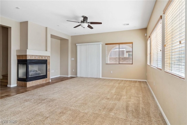 unfurnished living room with visible vents, carpet flooring, a fireplace, and baseboards