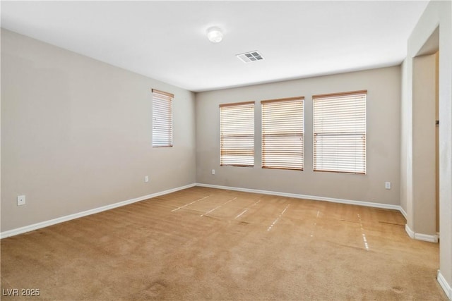 unfurnished room with light colored carpet, baseboards, and visible vents