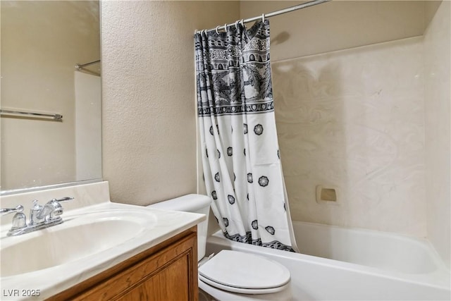 full bathroom featuring vanity, toilet, shower / bath combo, and a textured wall