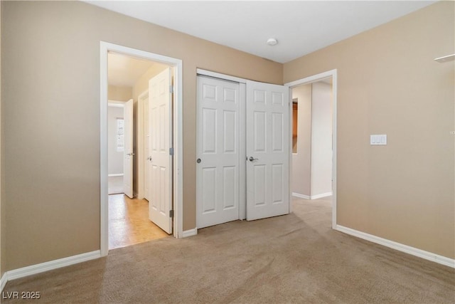 unfurnished bedroom featuring a closet, baseboards, and carpet floors