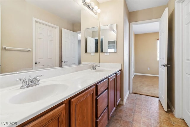 bathroom featuring double vanity, baseboards, and a sink