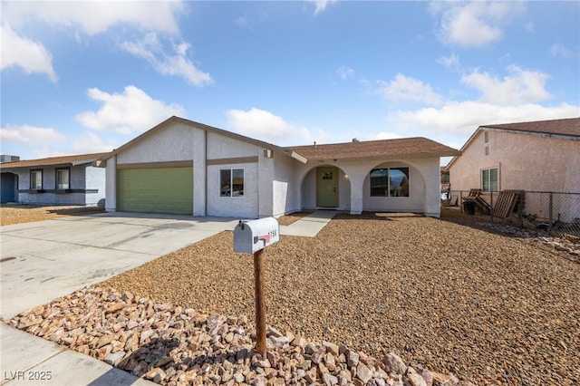 ranch-style home featuring concrete driveway, an attached garage, fence, and stucco siding