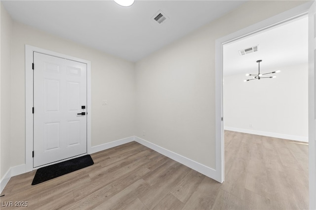 foyer with light wood-type flooring, baseboards, and visible vents